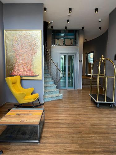 a living room with a yellow chair and a painting at the season in Karlsruhe