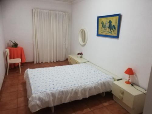 a small bedroom with a bed and a table at Apartamento Tiago in Sines