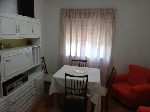 a dining room with a table and a red chair at Apartamento Tiago in Sines