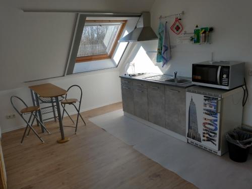 a kitchen with a microwave and a table in it at Apartment an den Teichen in Lengede