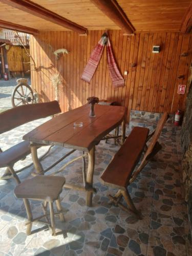 a wooden table and chairs in a room at Pensiunea Bujor de Munte in Cîrţişoara