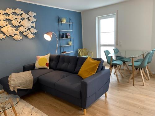 a living room with a blue couch and a table at Ferienwohnungen Bohner/Ferienwohnung Maria in Meersburg