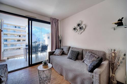 d'un salon avec un canapé et un balcon. dans l'établissement agreable 2 pieces avec piscine a1b235, à Cannes