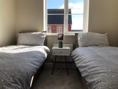 a bedroom with two beds and a window at Hill House - 5 Mins Merry Hill - Perfect for Contractors & Families in Brettell Lane