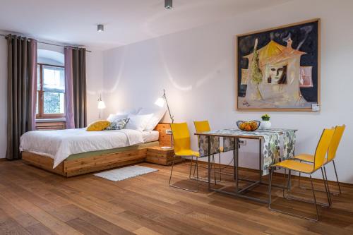 een slaapkamer met een bed en een tafel en stoelen bij Vila Vipolže - Rooms & J. Suites in Vipolže