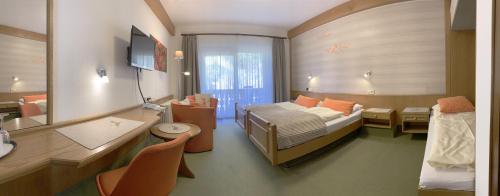 a hotel room with a bed and a desk and a room at Landhotel Untere Kapfenhardter Mühle in Unterreichenbach