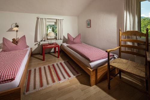 a bedroom with two beds and a chair and a window at Villa Aldefeld in Berchtesgaden