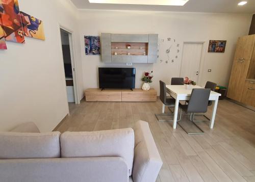 ein Wohnzimmer mit einer Couch und einem Tisch und einem Fernseher in der Unterkunft B&B Sweet Home in Grumo Appula