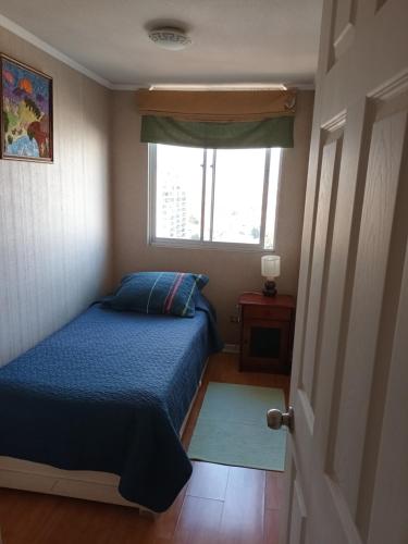 Habitación pequeña con cama y ventana en hospedaje en departamento compartido, en Valparaíso