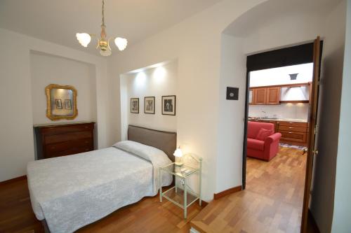 ein Schlafzimmer mit einem Bett und einem roten Stuhl in der Unterkunft Soana Apartment in Genua