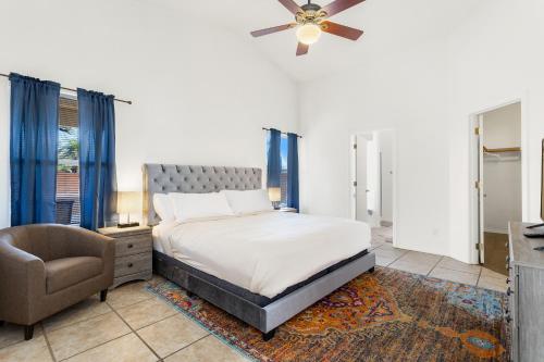 Sonesta Tucson home في توسان: غرفة نوم بسرير وكرسي ومروحة سقف