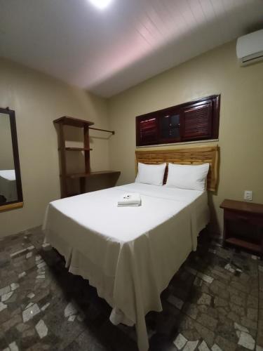 um quarto com uma grande cama branca num quarto em Pousada Pouso Da Praia em Cumbuco