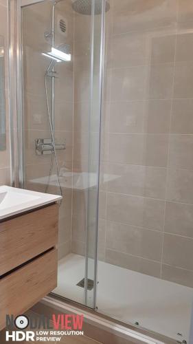 une douche avec une porte vitrée dans une salle de bain dans l'établissement bord de Mer et pieds dans l'eau, à Saint-Cyprien