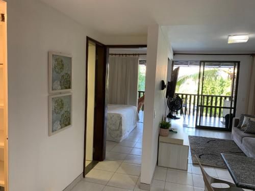 1 dormitorio con 1 cama y sala de estar en Nannai Residence Flat - Muro Alto, en Porto de Galinhas