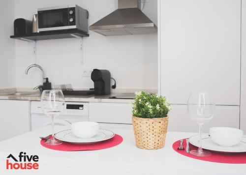 a white kitchen with two wine glasses and a plant at Five House 14B in Porto