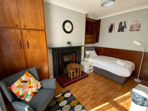 a small bedroom with a bed and a fireplace at Sandymount Studios in Dublin