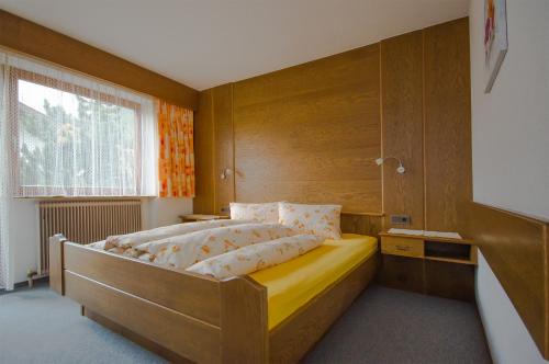 Un dormitorio con una cama con paredes de madera y una ventana en Haus Alpengruß, en Sölden