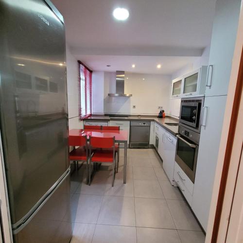 uma cozinha com um frigorífico de aço inoxidável e uma mesa em Matilla Place em Baeza