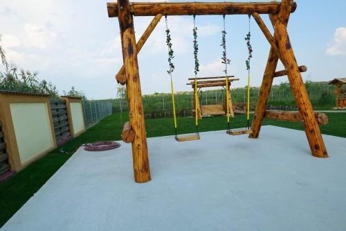 a playground with a wooden swing at Casa Vlad in Murighiol