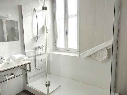 a bathroom with a glass shower and a sink at Hôtel Restaurant de France in Castelnaudary