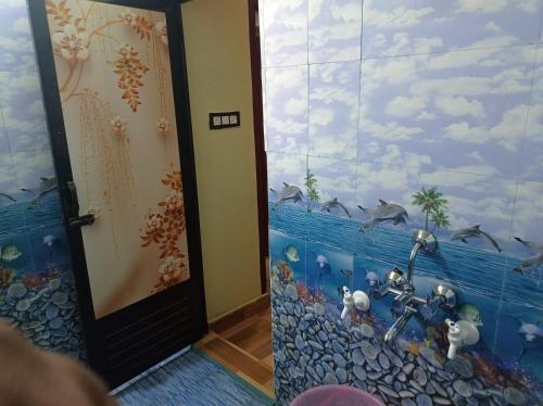 a bathroom with a fish mural on the wall at Dreams River view homestay coorg B in Kushālnagar