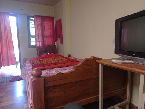 a small bedroom with a bed and a television at Dreams River view homestay coorg B in Kushālnagar