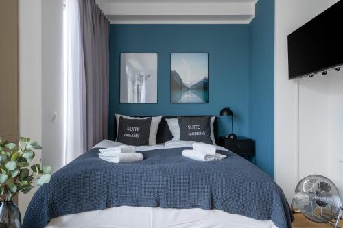 a blue bedroom with a bed with towels on it at Limehome Potsdam Annemarie-Wolff-Platz in Potsdam