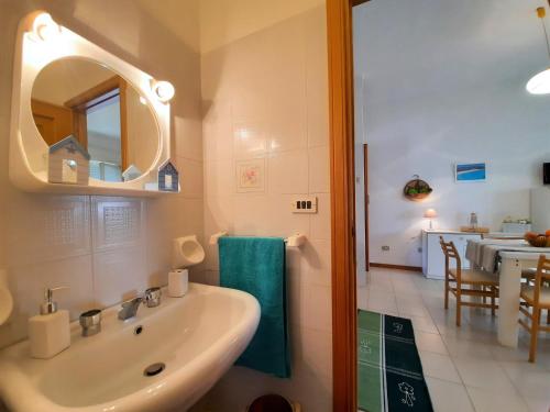 a bathroom with a sink and a mirror and a table at Apartment Malta in Alghero