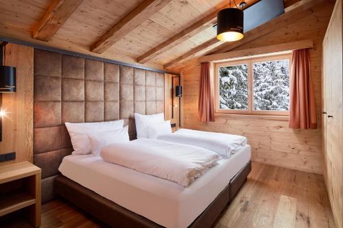 een slaapkamer met een groot bed in een houten kamer bij Zugspitz Lodge in Ehrwald