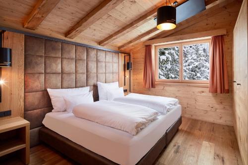 a bedroom with a large bed in a wooden room at Zugspitz Lodge in Ehrwald