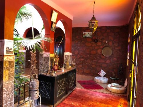 een kamer met een stenen muur en een kamer met een tafel bij Villa Siliya maga Cœur vallée amlen tafraout in Tafraoute