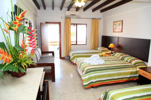 Habitación de hotel con 2 camas y mesa en Hotel Puerto Ballesta, en Tonsupa