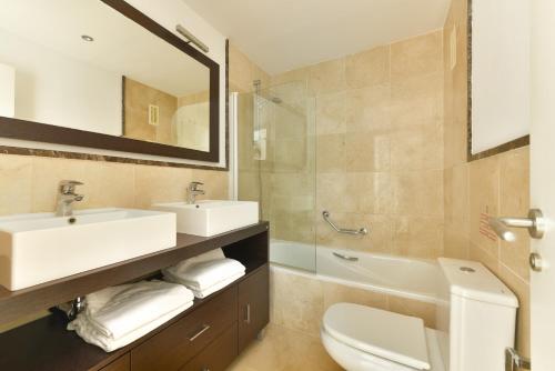 a bathroom with a sink and a toilet and a mirror at Exclusivo apartamento de 2 dormitorios vista mar lateral in Torrox Costa
