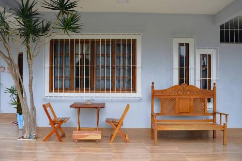 Zimmer mit 2 Stühlen, einem Tisch und einer Bank in der Unterkunft Casa Espetacular no Centro da Serra in Nova Friburgo