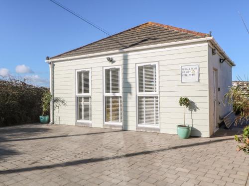 a small white building with a sign on it at Perran Pearl A in Perranporth