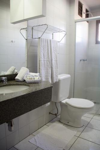 a bathroom with a toilet and a sink and a shower at Brumado Hotel in Campo Grande