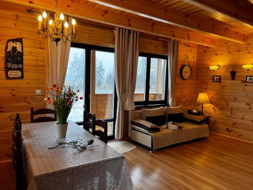 a living room with a couch and a table in a room at Świerkowy Domek pod Aniołem in Łapy