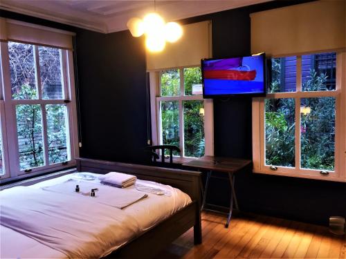 een slaapkamer met een bed en een flatscreen-tv bij Dreamers V&V Hotel Cihangir in Istanbul