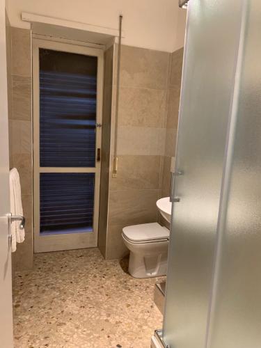 a bathroom with a toilet and a glass shower door at Catania Apartment Borgo Suite Autonomous in Catania