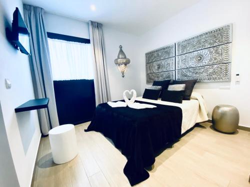 a bedroom with a black and white bed and a window at Hostal Alisol Boutique San Pedro in Marbella