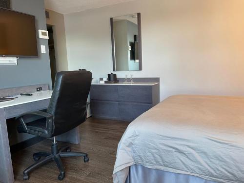 a room with a bed and a desk and a chair at Auberge de la Gare in Gatineau