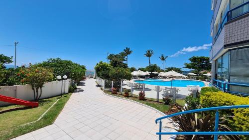 a resort with a swimming pool and a building at Costa Blanca Standard - Beira Mar in Florianópolis