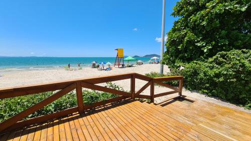 a wooden deck with a view of the beach at Costa Blanca Standard - Beira Mar in Florianópolis