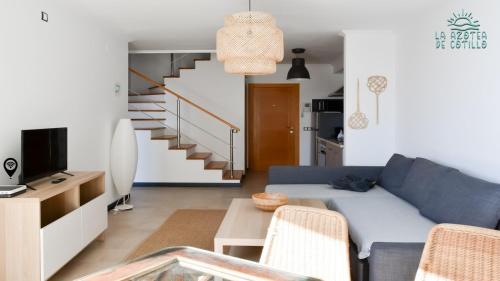 een woonkamer met een blauwe bank en een tafel bij Azotea de Cotillo in Cotillo