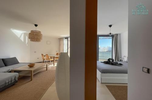 Una sala de estar con un sofá, una cama y una mesa. en Azotea de Cotillo, en Cotillo