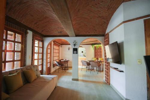 ein Wohnzimmer mit einem Sofa und einem TV in der Unterkunft Suites Paraiso Tequis in Tequisquiapan