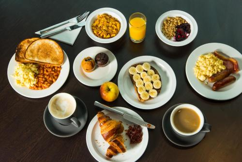 einen Tisch mit Frühstücksteller und Tassen Kaffee in der Unterkunft Holiday Inn Express Edinburgh City West, an IHG Hotel in Edinburgh