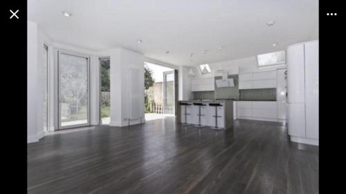 a large kitchen with wooden floors and white walls at Eglentine in London