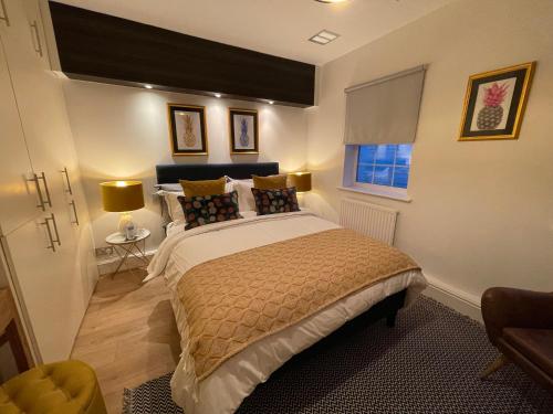 切爾滕納姆的住宿－52 Lansdown Crescent，一间卧室配有一张带两盏灯的床和一扇窗户。