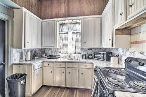 a kitchen with white cabinets and a sink at Cozy Livingston House with Fenced Yard and Patio! in Livingston